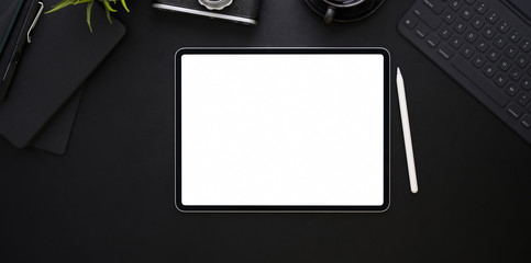 Top view of blank screen tablet on black leather background