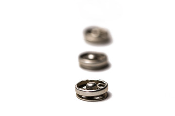 Close up of a group of metal Snap on Buttons on white background.