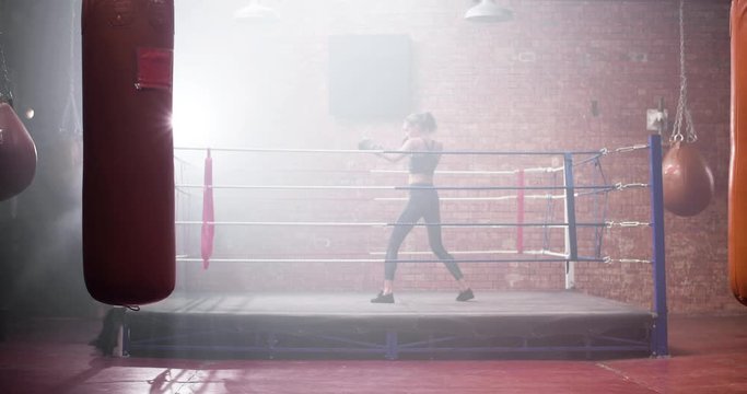 Young adult female boxer shadowboxing