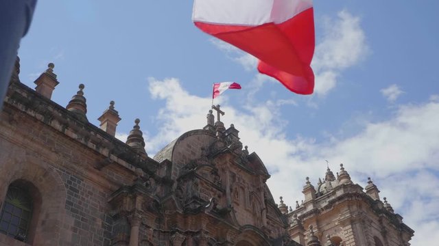 Slow motion footage of the cathedral of Cusco, Peru, with waving flags