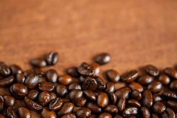 Freshly roasted scattered dark coffee beans, with mood filter, close up