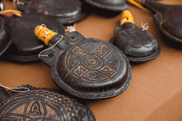 Ceramic flask in leather case with embossed and wooden stopper on the counter.
