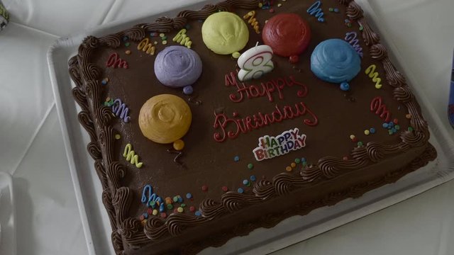 view from above of a brown chocolate kake with a beautiful decoration showing the words of happy birthday and a number 8