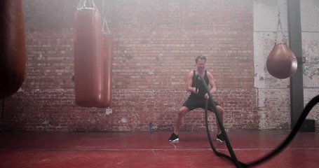 Adult male working out with battle ropes