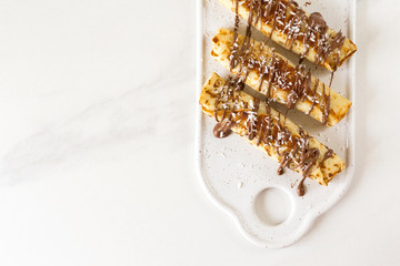 Pancakes rolls with cottage cheese and chocolate, coffee. Breakfast