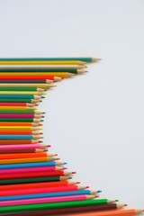 Composition semicircle made of mixed colored pencils on a white background.The concept of anti-stress, hobby.With selective focus,copy space for text.