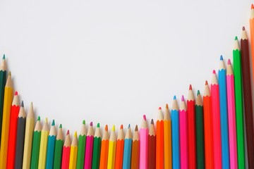 Composition semicircle made of mixed colored pencils on a white background.The concept of anti-stress, hobby.With selective focus,copy space for text.