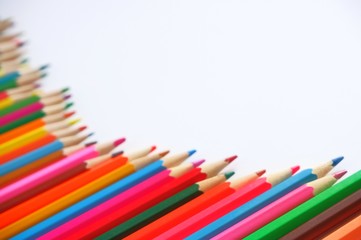 Blurred image composition semicircle made of mixed colored pencils on a white background.The concept of anti-stress, hobby.With selective focus,copy space for text.