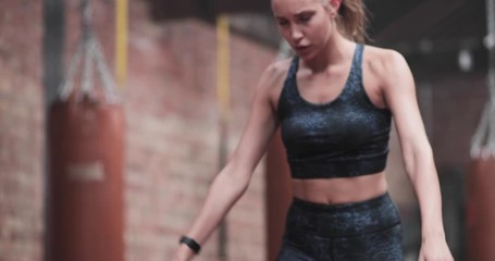 Young adult female flipping tire for a body building workout