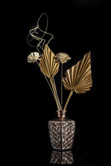 Dry flowers on a modern metal vase creating a beautiful abstract still-life composition