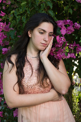 Attractive young beautiful lady, enjoying the pink blooming  flowers. Concept of welcoming Spring