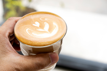 Hot latte in hand ready to drink