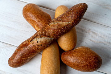 different mini baguettes on white wooden table