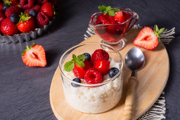 delicious milk rice with different berries and red fruit jelly