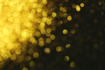 Golden glitter blurred background. Gold on black. Soft focus. Christmas and New Year shining  background