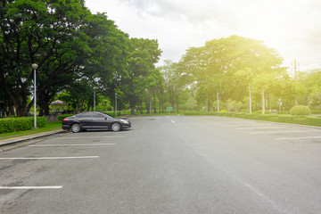 The parking lot in Chatuchak Park is surrounded by trees.