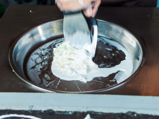 Making rolled ice cream. Man hands making kiwi and banana Thay style natural ice cream