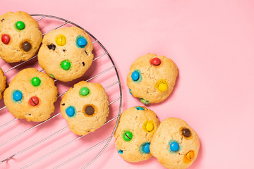 Homemade cookies decorated with colorful jelly beans candies on pink background. Top view flat layout. Holiday concept.