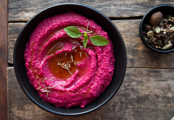 Beetroot hummus. Healthy vegan appetizer on a wooden background