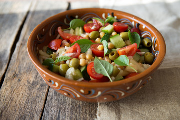 Bowl with healthy salad and dip. Close-up. Buddha bowl with chickpea avocado quinoa seeds tomato olives fresh basil brussels sprout lime mix. Vegetarian salad. Clean healthy eating concept