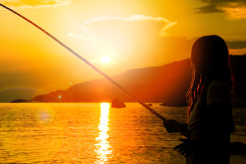 happy child fishing by the sea silhouette