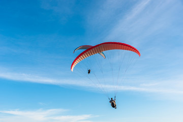 Paragliding Extreme sport, Paraglider flying on the blue sky and white cloud in Summer day at Phuket Sea, Thailand.