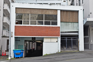 Old concrete building with roller door and half basement in downtown Auckland