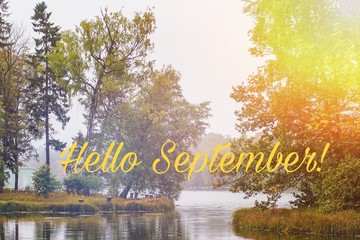 Hello September banner. New month. Greeting card. Golden autumn. The text in the photo. Trees in the park. City Park. Autumn Park