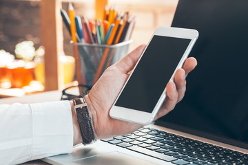 Man using mobile smart phone. Business man hands using cell phone at office desk.