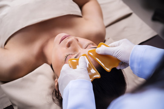 woman receiving traditional guasa face therapy