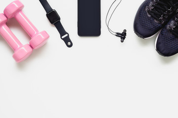 Fit health lifestyle and weight lose diet background concept. Fitness equipment running shoes,dumbbells, smartwatch,smartphone, earphone on white background.