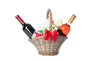 Wicker basket with bottles of wine and presents isolated on white background