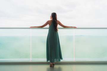 Beautiful portrait young asian woman happy smile relax at balcony with sea ocean