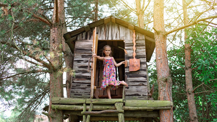 Happy cute kid playing in the treehouse
