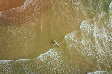 Obraz premium Aerial view on surfer in the sea, surfer catching waves in baltic sea.
