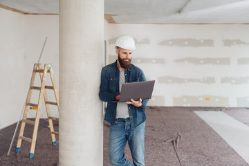 Builder or architect using laptop computer on site