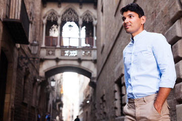 young European guy in blue shirt walking around city