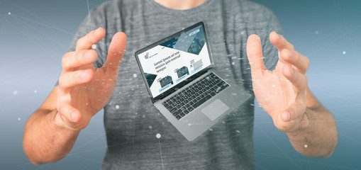 Businessman holding a Laptop with business website template on the screen isolated on a background