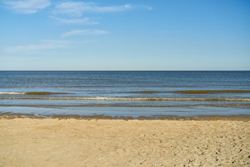 Fototapeta na wymiar Strand mit Sand vor Meer und Himmel mit Wolken