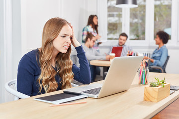 Business Frau sitzt gestresst am Laptop Computer