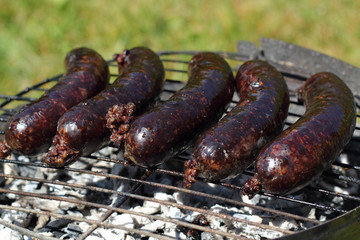 Grilling Blood Sausages on barbecue grill