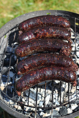 Grilling Blood Sausages on barbecue grill