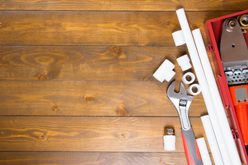 polypropylene pipes and soldering tool, on a dark wooden background, there is a place for the...