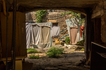 Picture for decoration of a vintage retro interior. Odessa. An old authentic courtyard with an arch and dried clothes on the ropes. Dry freshly washed clean laundry outdoors