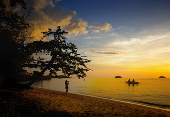 amazing landscape of sea and tropical beach in Thailand at sunset time for vacation(selective focus at oarsman and boat)