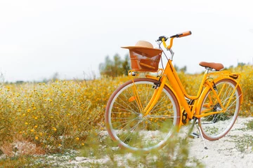 Schilderijen op glas Reisconcept. Foto van gele fiets, in een kleurrijk veld met gele bloemen, © Vulp