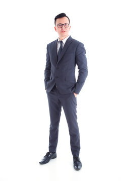Full length of handsome asian businessman wearing suit standing and smiling isolated over white background