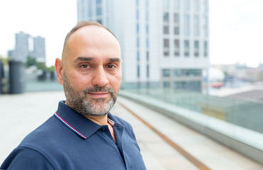 Portrait of a mature man on a city background. Ordinary people.