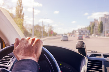 The driver's hands on the steering wheel of the car