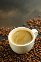 coffee drink in white cup and sprinkle coffee beans on the table. food background. top. copy space